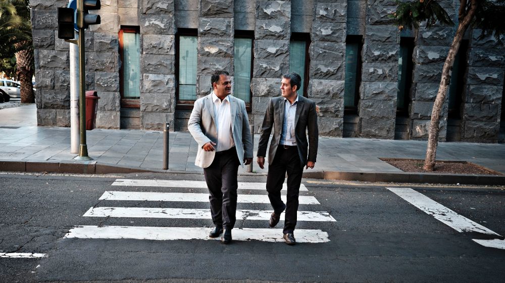 Fernando Clavijo (d) y el alcalde de La Laguna, José Alberto Díaz, cruzan la calle frente a la sede de la Presidencia del Gobierno en Santa Cruz de Tenerife.