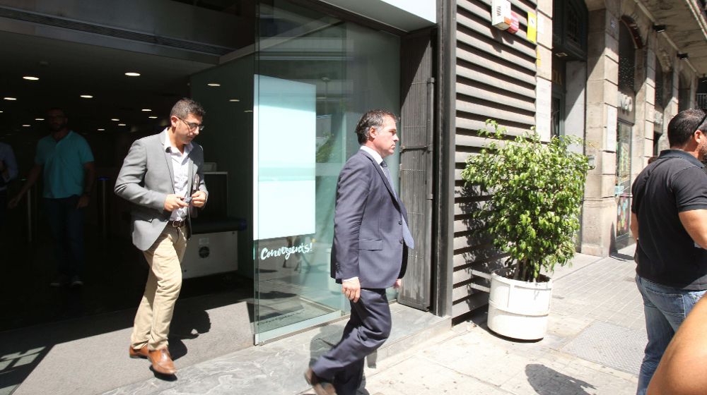Efectivos de la Fiscalía Anticorrupción abandonan la sede central de CDC en Barcelona, donde se han presentado con una orden de registro.
