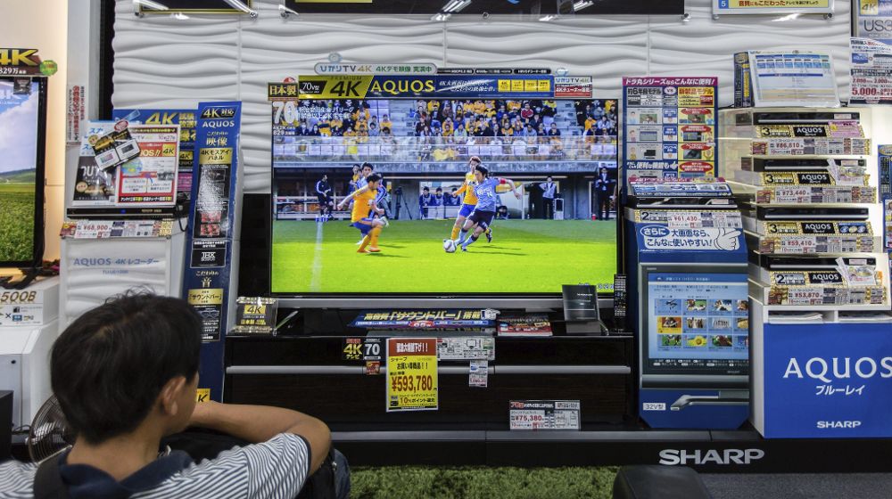 Un hombre mira una pantalla Sharp AQUOS 4K LED TV en una tienda de electrónica en Tokio (Japón).