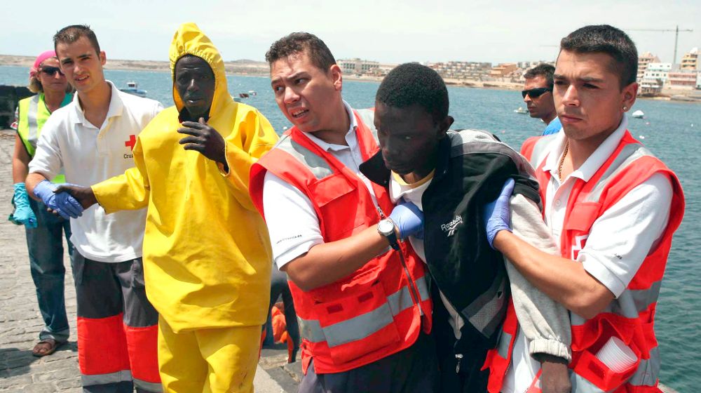 Inmigrantes indocumentados ayudados por miembros de la Cruz Roja.