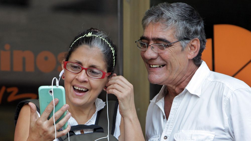 Fotografía del 28 de agosto de 2015 de dos personas revisando el celular durante su coneccion con Wifi, en La Habana, Cuba.