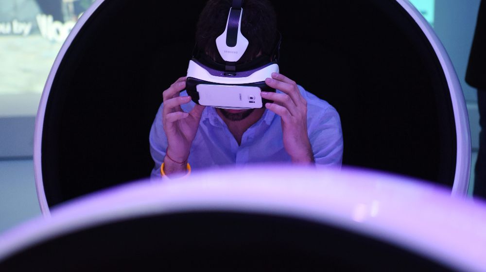 Visitantes prueban un casco de realidad virtual conectado a un teléfono inteligente.