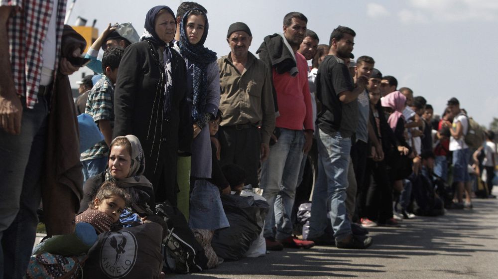 Refugiados, en su mayoría sirios, esperan para subir a un autobús tras desembarcar del ferry "Eleftherios Venizelos" en el puerto del Pireo en Grecia.