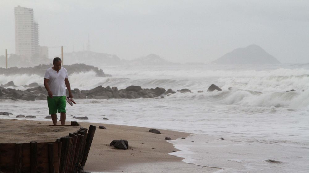 Un hombre camina hoy, martes 8 de septiembre de 2015, en una playa frente a grandes olas.