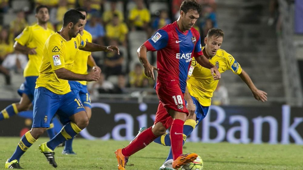 El centrocampista del Levante UD Víctor Casadesús (c) se escapa del argentino Juan Culio (i) y Dani Castellano (d), de la UD Las Palmas.
