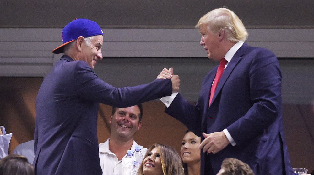 El candidato presidencial republicano Donald Trump (d) saluda al extenista John McEnroe (i).