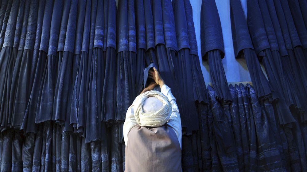 Un hombre afgano vende burkas en su tienda.