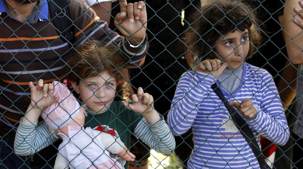 Dos niños refugiados esperan para registrarse tras haber cruzado la frontera entre Serbia y Croacia en Tovarnik, Croacia.