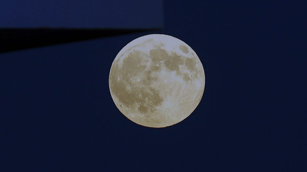 Imagen de archivo en el que la luna sale por detrás de un edificio.