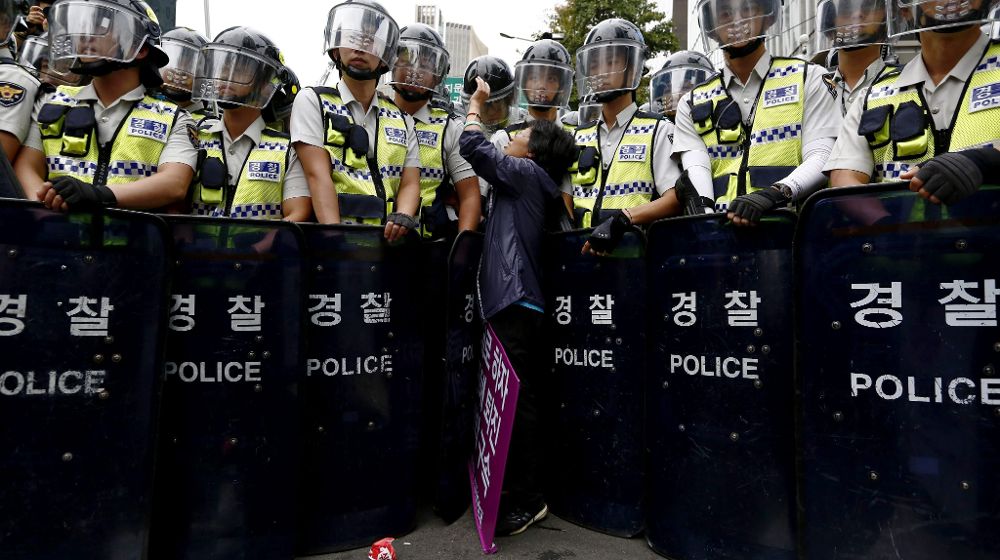 Una mujer se encara con un agente antidisturbios durante durante una protesta organizada por la Confederación de Sindicatos de Corea (CSC).