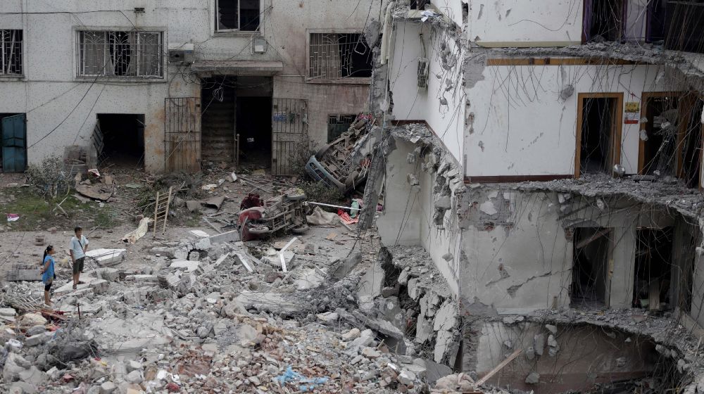 Varios residentes observan los destrozos registrados en un edificio parcialmente derrumbado por una explosión provocada, presuntamente, por los explosivos ocultos en parcelas en el condado de Liucheng, en la región autónoma de Guangxi (China).