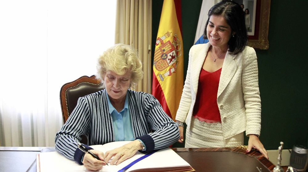 La Defensora del Pueblo, Soledad Becerril firma en el libro de honor de visitas del Parlamento de Canarias en presencia de la presidenta de la cámara, Carolina Darias.