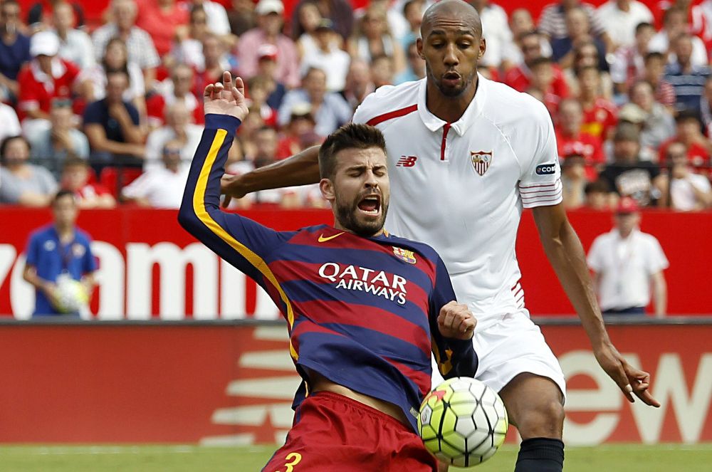 El centrocampista francés del Sevilla Steven N'Zonzi (d) disputa un balón con el defensa del FC Barcelona Gerard Piqué.