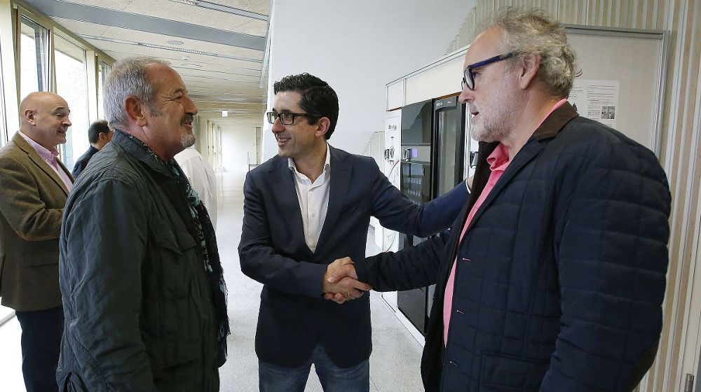 El director general del Basque Culinary Center, Joxe Mari Aizega (c), saluda a los cocineros Carlos Argiñano (i) y Ramon Roteta (d).