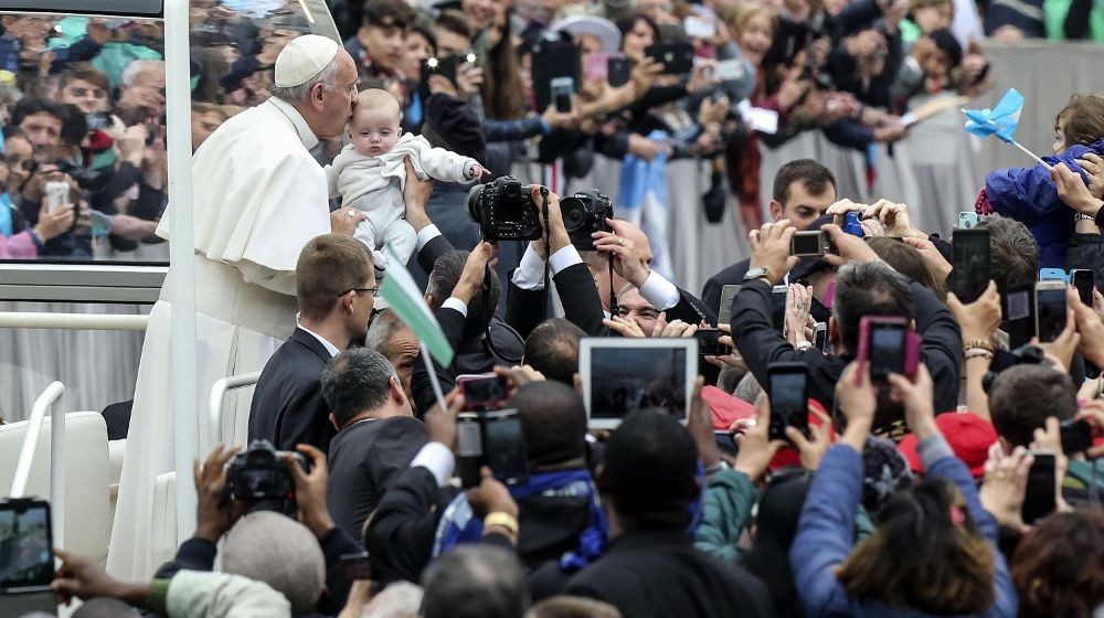 El papa Francisco besa a un bebé a su llegada a la audiencia general de los miércoles en la plaza de San Pedro del Vaticano, hoy, 28 de octubre.