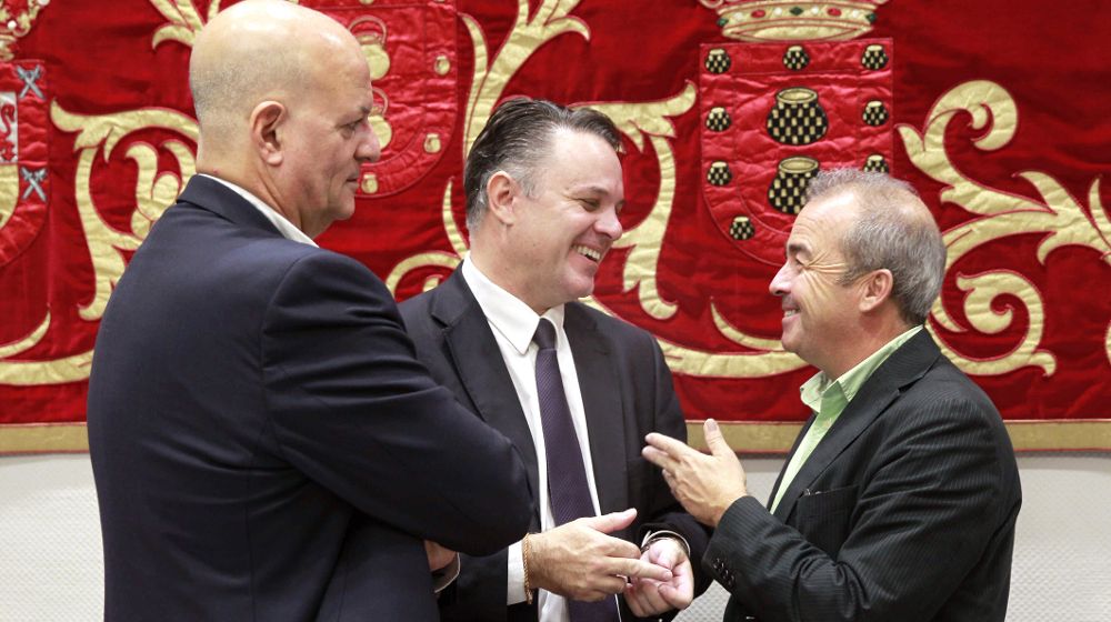 El presidente del Consejo Rector de Radiotelevisión Canaria (RTVC), Santiago Negrín (c), conversa con los diputados de CC, José Manuel Pitti (i), y de Podemos, Francisco Deniz, antes de comenzar la comisión.