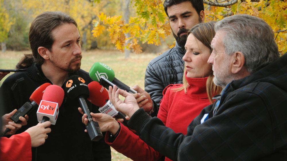 El secretario general de Podemos, Pablo Iglesias (i), atiende a los medios en el antiguo campamento de Robledo, en Segovia.