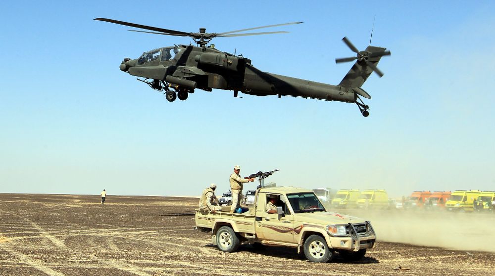 Un helicóptero y un vehículo del Ejército egipcio vigilan el área por donde están esparcidos los restos del accidente.