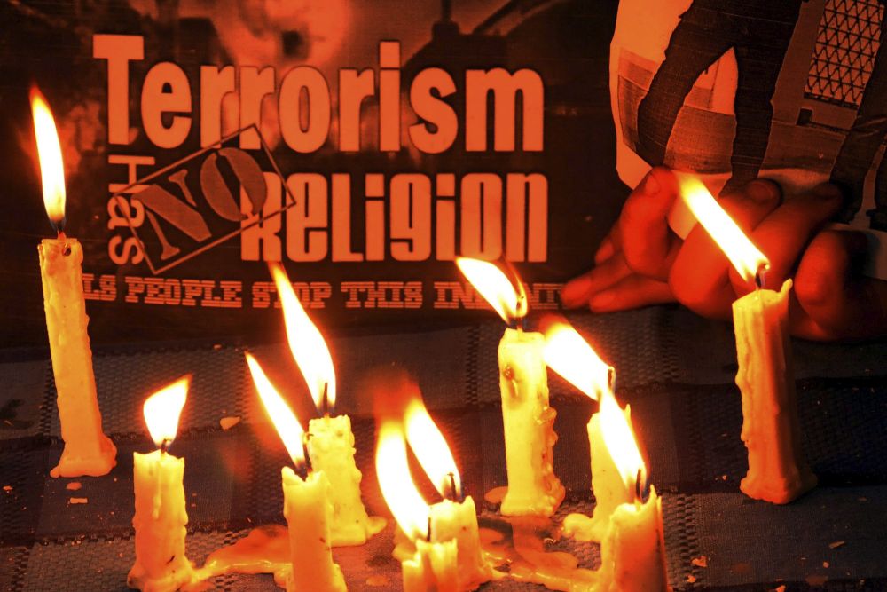 Niños indios encienden velas durante una ceremonia en memoria de las víctimas de los atentados de París.