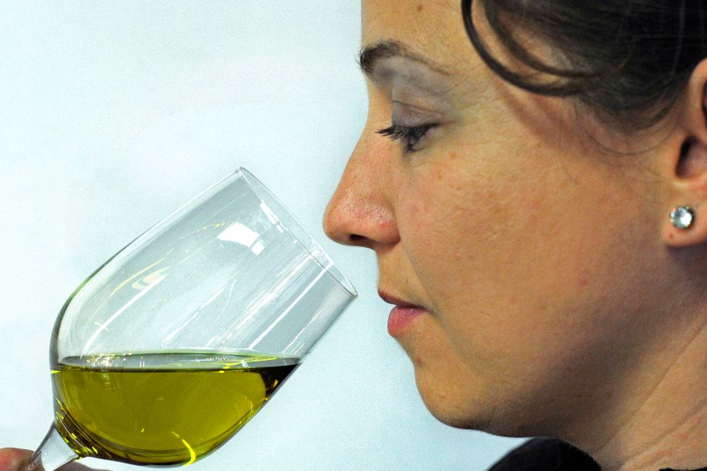 Una visitante cata un aceite de oliva.