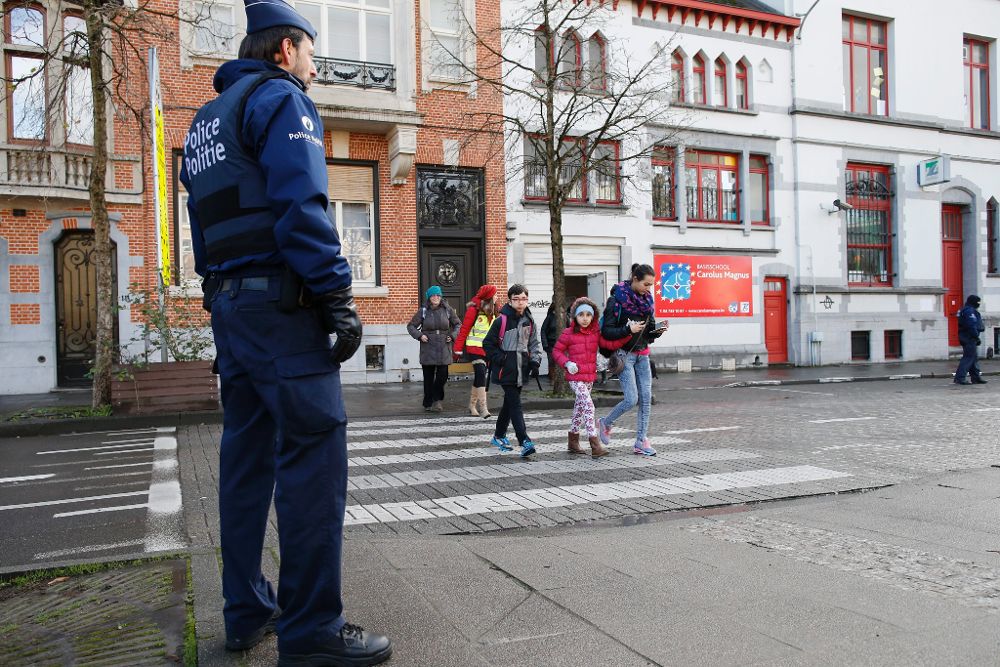 Un policía belga hace guardia a las puertas de un colegio en Bruselas.