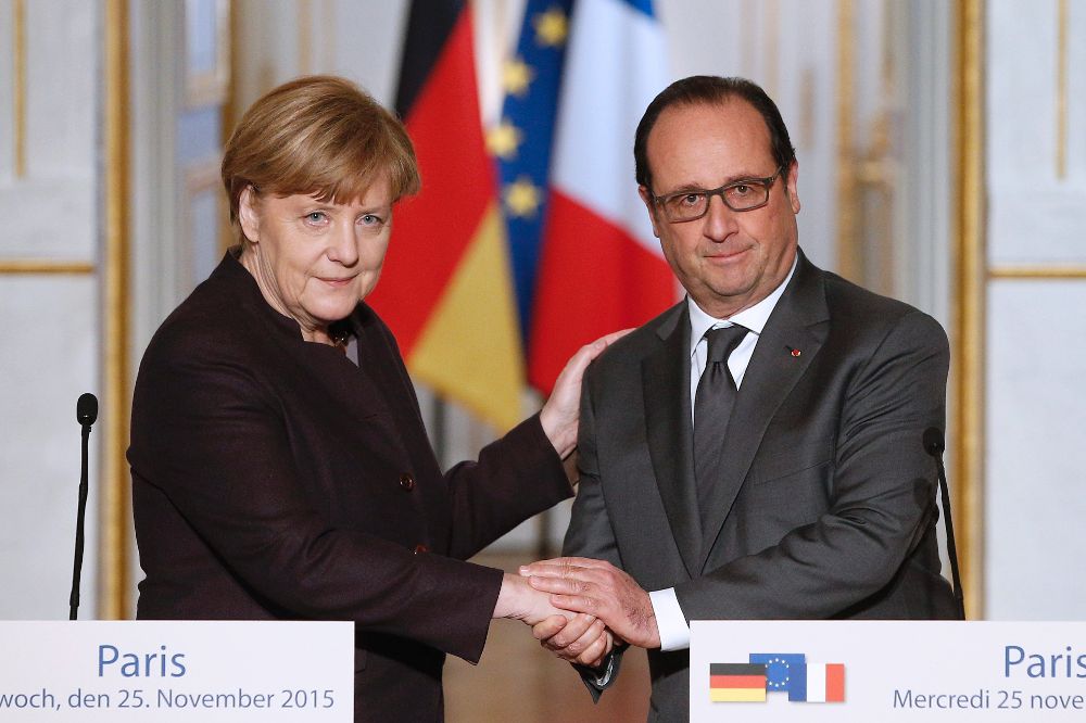 El presidente francés, François Hollande (d), saluda a la canciller alemana, Angela Merkel (i), tras pronunciar un discurso en el Palacio del Elíseo de París, Francia, hoy 25 de noviembre de 2015. 