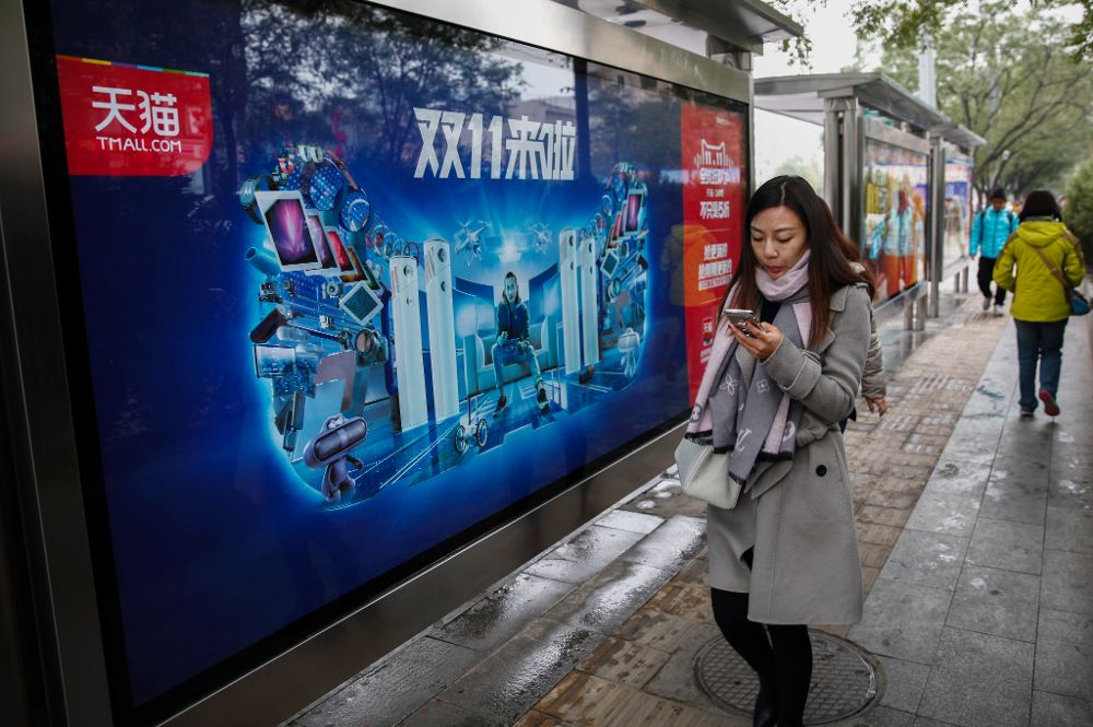 Una mujer pasa por delante de un anuncio publicitario de comercio comercio online en Pekín (China).