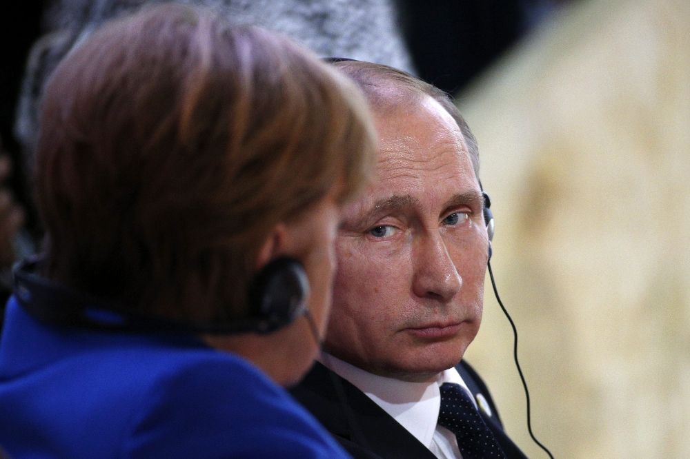 El presidente ruso, Vladimir Putin (dcha), conversa con la canciller alemana, Angela Merkel (izda).