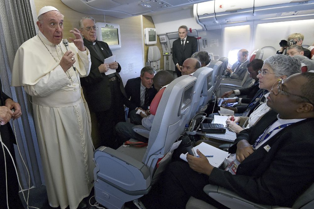 El papa Francisco (i) se dirige a los periodistas durante el vuelo que lo trasladaba desde Bangui hasta Roma.