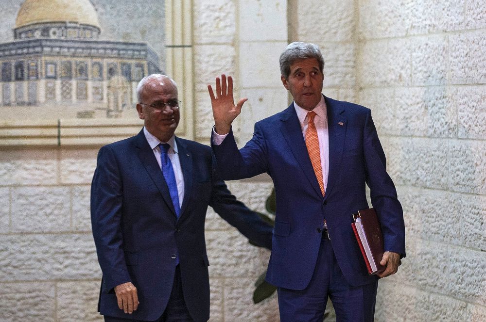El secretario de Estado estadounidense, John Kerry (dcha), es recibido por el jefe negociador palestino, Saeb Erekat (2i).