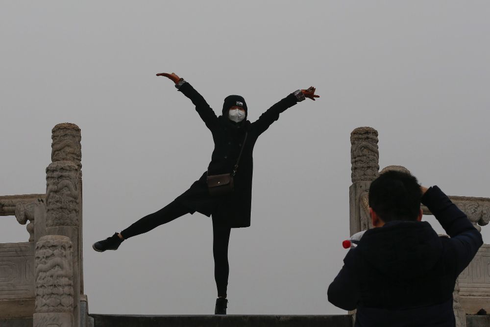 Una mujer posa para una foto mientras usa una mascarilla para protegerse contra la contaminación ambiental.