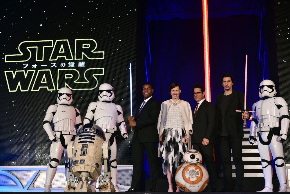 Los actores británicos, John Boyega (i) y Daisy Ridley (2-i), el estadounidense Adam Driver (d) y el director J.J Abrams (2-d), posan junto a los personajes de la película durante el estreno del Episodio VII de "Star Wars: el despertar de la Fuerza" en Tokio.
