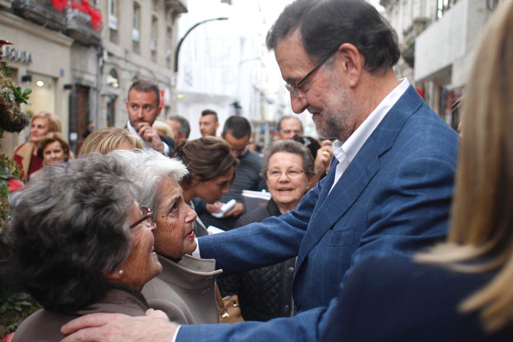 Mariano Rajoy conversa con dos mujeres durante el recorrido que ha hecho hoy por las calles de Vigo.