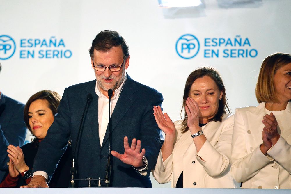 El presidente y candidato del Partido Popular a la Presidencia del Gobierno, Mariano Rajoy, acompañado de su esposa, (2ºd), se dirige a sus simpatizantes en el exterior de la sede de su partido en la calle Génova.