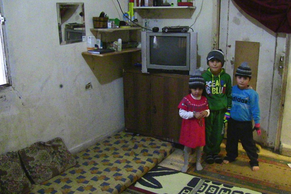 Tres de los hijos de Hader, un refugiado sirio que vive junto a su familia en un edificio a medio construir en Dbaye (Líbano).