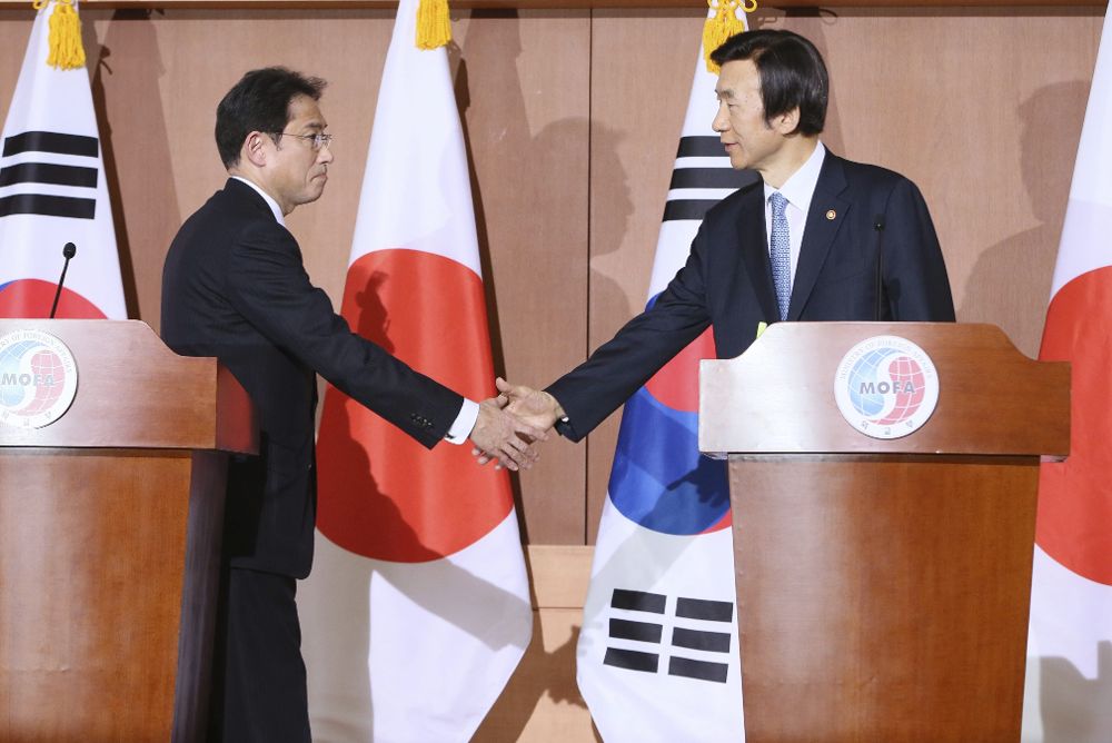 El ministro nipón de Exteriores, Fumio Kishida (izda), y su homólogo surcoreano, Yun Byung-Se, estrechan la mano durante una rueda de prensa en Seúl.