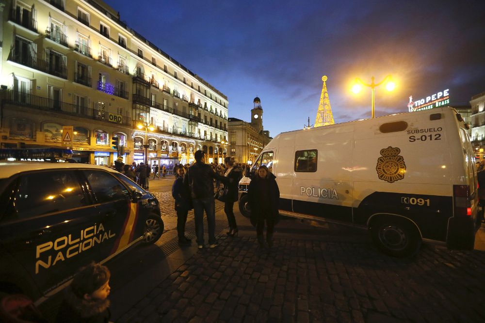 Vehículos policiales en la madrileña Puerta del Sol. El dispositivo de seguridad para las "preuvas" y uvas de año nuevo prevé que sólo 25.000 personas podrán acceder al lugar.