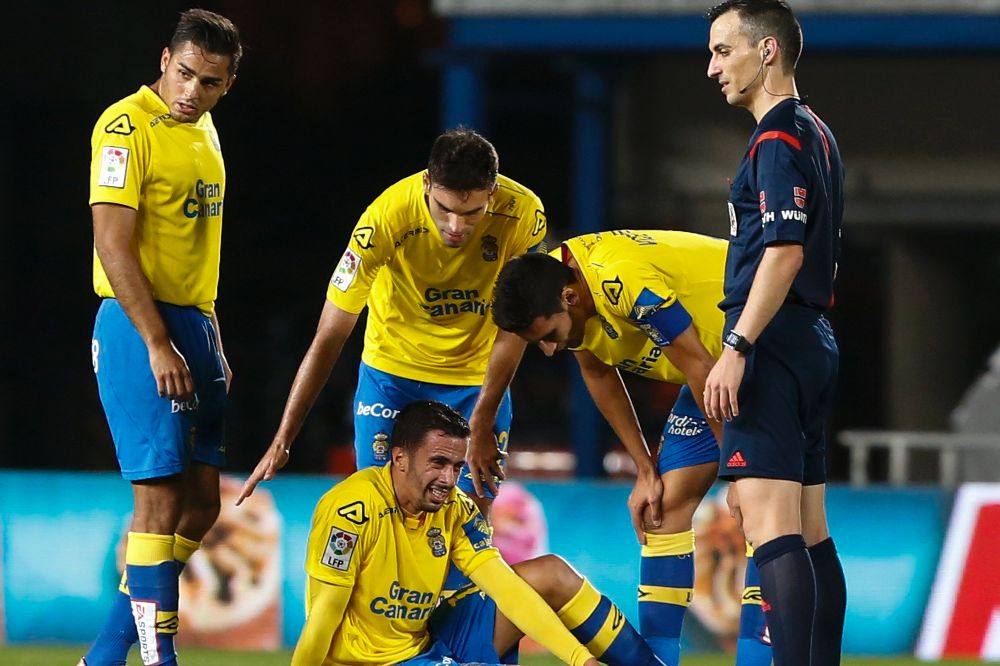 El defensa de la UD Las Palmas Hernán (c) se lesiona en el partido de la decimoséptima jornada de Liga en Primera División.