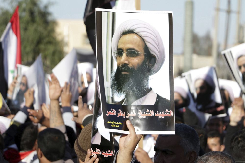 Cientos de personas portan retratos del clérigo opositor chií saudí, Nimr Baqir al Nimr durante una manifestación en Bagdad, Irak.