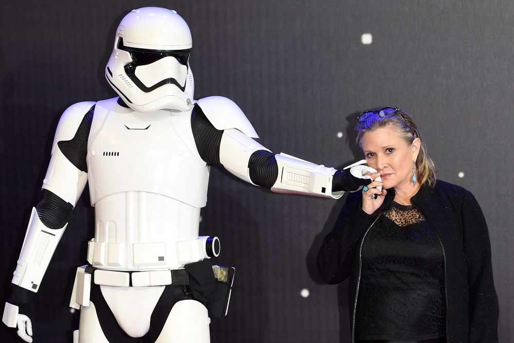 La actriz estadounidense del reparto Carrie Fisher posa junto a uno de los personajes Stormtrooper.