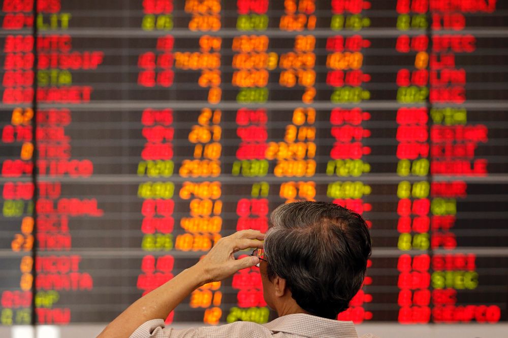 Un inversor observa un panel electrónico con los resultados de la Bolsa de Valores de Bangkok (Tailandia).