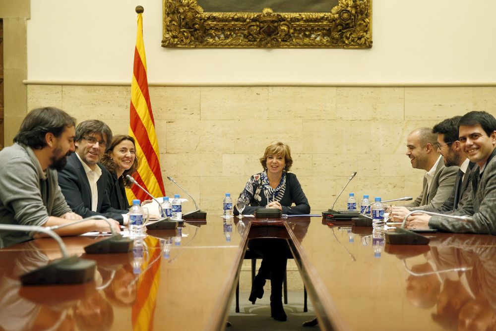 Carles Puigdemont (2i), con la consellera de Gobernación en funciones, Meritxell Borràs (c), durante una reunión con alcaldes de los cinco ayuntamientos denunciados por la Fiscalía de la Audiencia Nacional por apoyar la declaración rupturista del Parlament.
