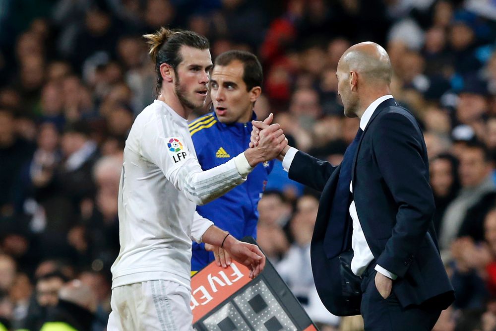 El delantero galés del Real Madrid, Gareth Bale (i), saluda al técnico francés del equipo blanco, Zinedine Zidane.