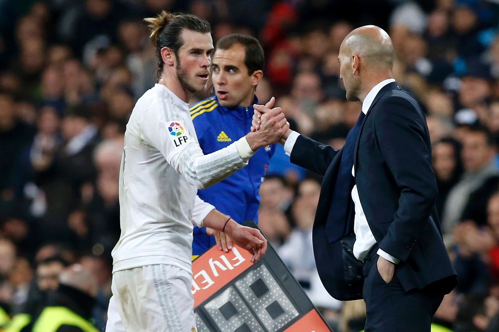 El delantero galés del Real Madrid, Gareth Bale (i), saluda al técnico francés del equipo blanco, Zinedine Zidane, al ser sustituido durante el encuentro correspondiente a la decimonovena jornada de primera división, que disputan esta noche frente al Deportivo en el estadio Santiago Bernabéu, en Madrid.