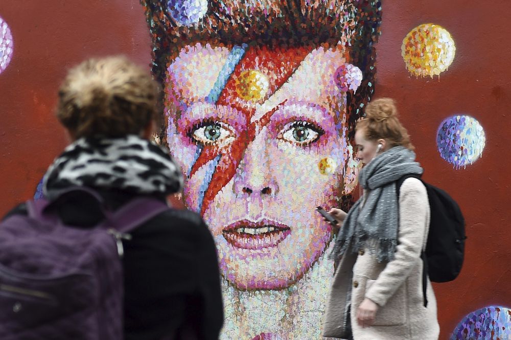 Dos mujeres frente a un mural del cantante británico David Bowie en Brixton, Londres.