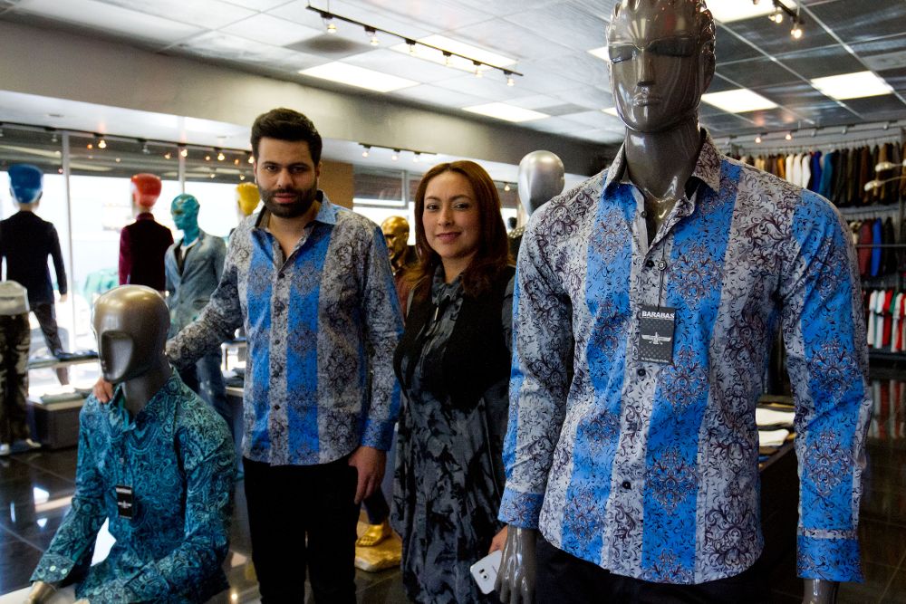 El cofundador de la marca Barabas, Shawn (i) y la gerente de tienda, Sandra Macía, posan con dos maniquíes vestidos con camisas iguales a la que vestía "El Chapo" en la entrevista que realizó el actor Sean Penn. 