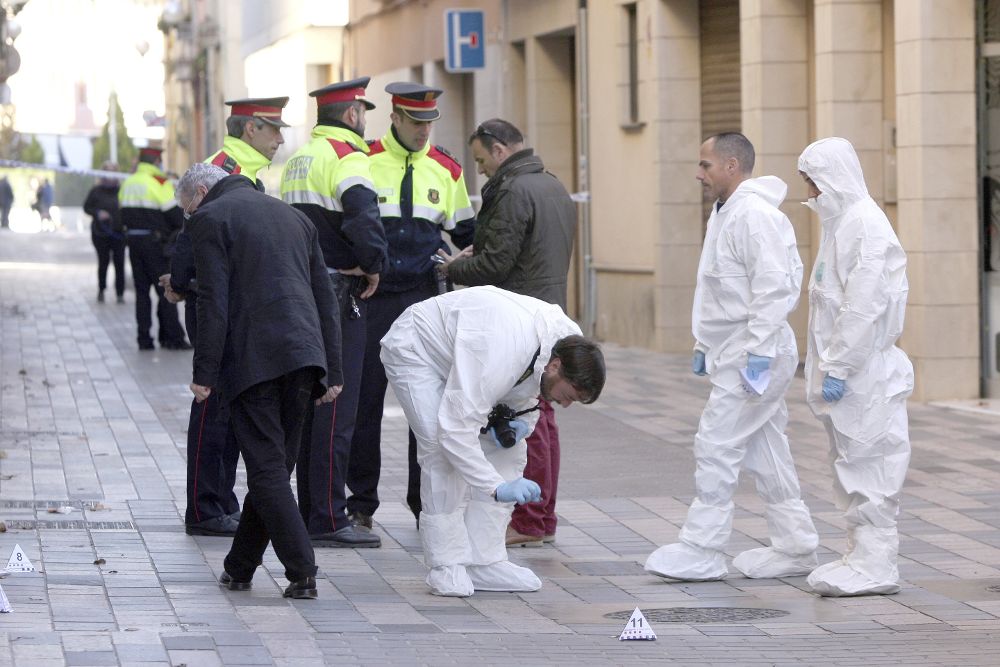 Mossos d'esquadra recogen pruebas en el lugar donde un hombre ha matado esta mañana a tiros a una mujer en plena calle en la población de Vila-seca (Tarragona) y posteriormente se ha suicidado.