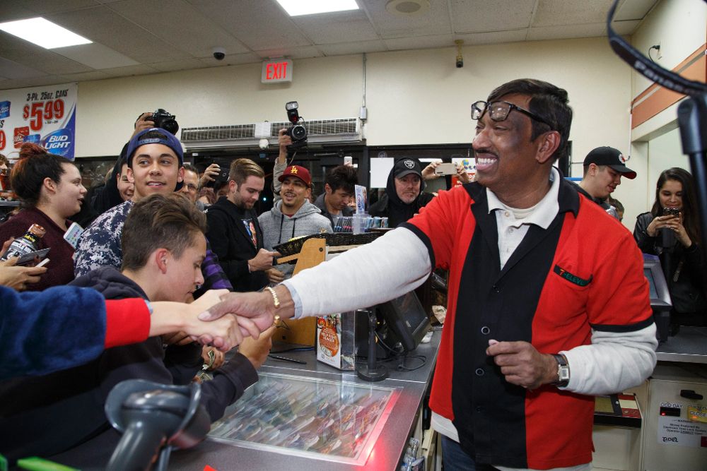 Una multitud felicita a M. Faroqui (dcha), empleado del establecimiento donde se vendió una de las tres apuestas ganadoras del sorteo de lotería con el mayor premio de la historia de Estados Unidos; 1.500 millónes de dólares, en Chino Hills, California.