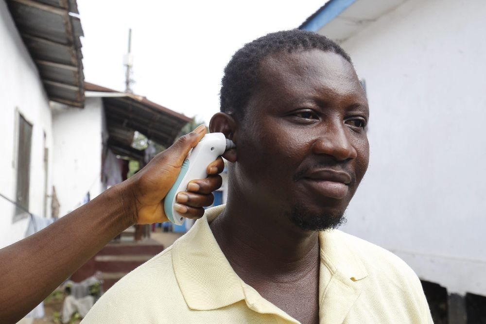 Un médico toma la temperatura de un hombre en Monrovia, Liberia, en un control de la epidemia de ébola.