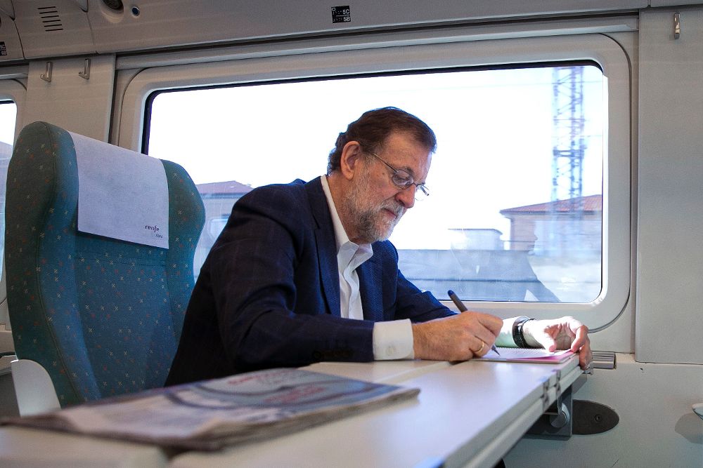 Fotografía facilitada por el PP de Mariano Rajoy, tomando notas en el tren en el que viaja hacia Zamora, donde participa en un acto del Partido Popular.